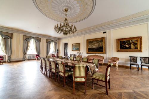 a dining room with a table and chairs and a chandelier at Burbiskio dvaras in Anykščiai