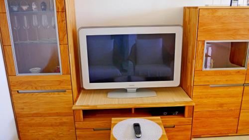 una televisione seduta su un supporto di legno con telecomando di Fewo Gruber a Erlangen