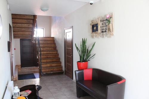 a living room with a black chair and a staircase at Windrose in Liepāja