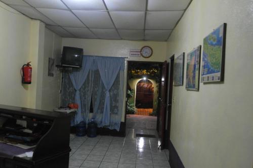 ein Zimmer mit einem Flur mit einer Uhr an der Wand in der Unterkunft Hostal Nicaragua Guest House in Managua