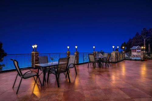 un gruppo di sedie e tavoli su un balcone di notte di Summit Grace Boutique Hotel & Spa a Darjeeling