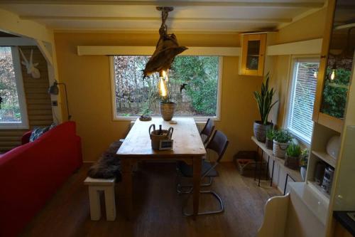 a living room with a table and some windows at vakantiehuis op de veluwe in Wolfheze