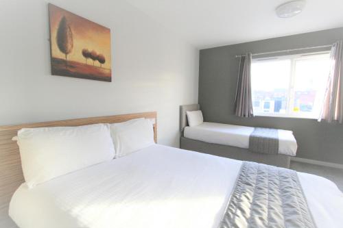 a bedroom with two beds and a window at Citilodge Wakefield Hotel by Roomsbooked in Wakefield