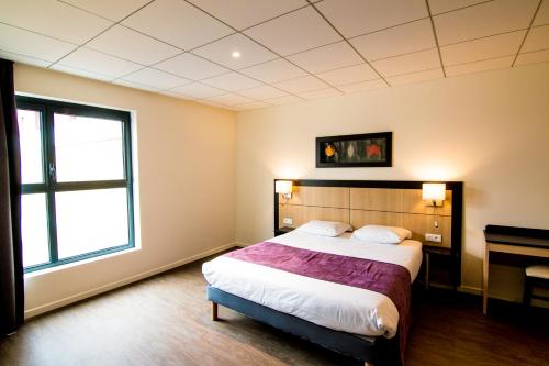 Tulip Inn Thionville Residences في تيونفيل: غرفة نوم بسرير كبير ونافذة