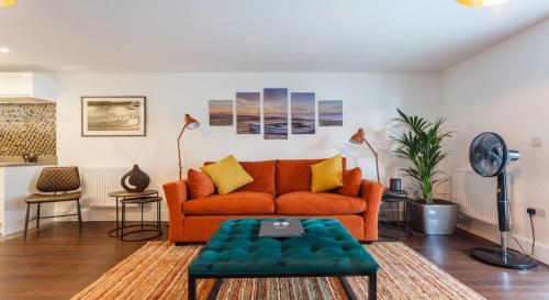 uma sala de estar com um sofá laranja e uma mesa em Stay@Coast em Bournemouth