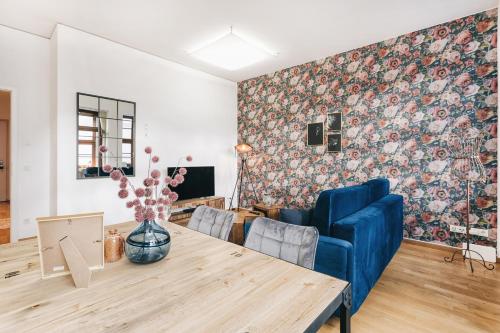 een woonkamer met een tafel en een blauwe bank bij Apartment an der Frauenkirche, Salzgasse, FEWO-Residenz-Dresden in Dresden