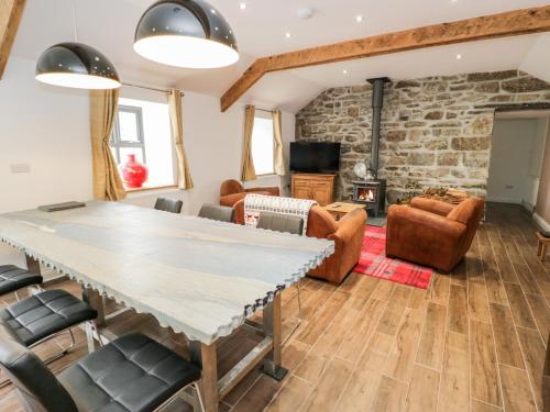 ein Wohnzimmer mit einem großen Tisch und Stühlen in der Unterkunft Rhydau Cottage in Bangor