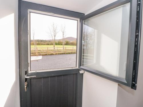 eine Tür in einem Zimmer mit Fenster in der Unterkunft Rhydau Cottage in Bangor