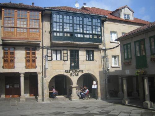 un edificio con gente sentada fuera de él en Hotel Restaurante Rúas, en Pontevedra