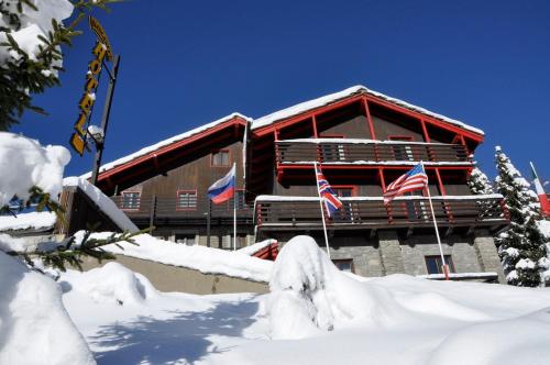 two flags in the snow in front of a building at Hotel Biancaneve in Sestriere