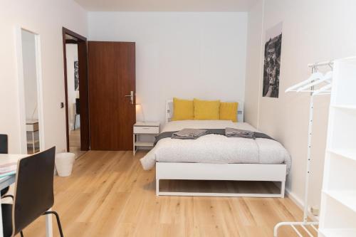 Habitación blanca con cama y escritorio en Park City Center, en Luxemburgo