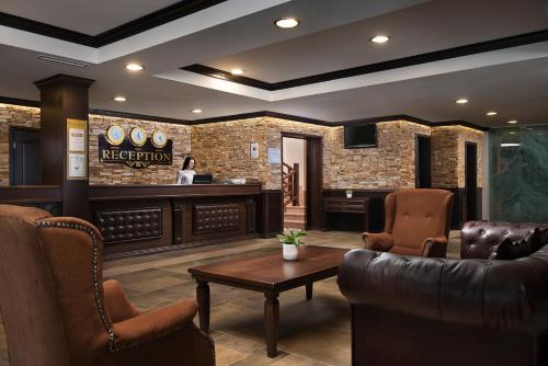 a lobby with a waiting room with a table and chairs at Royal Park Hotel & Apartments in Bansko