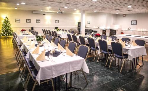 une salle de banquet avec des tables et des chaises ainsi qu'un sapin de Noël dans l'établissement Thon Partner Hotel Narvik, à Narvik