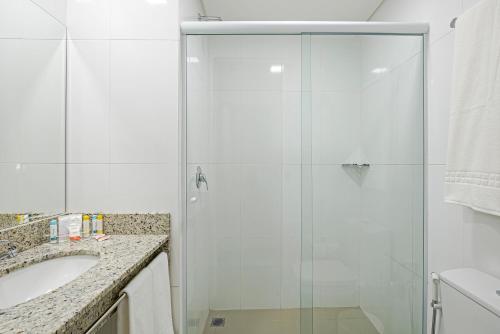 bagno con doccia in vetro e lavandino di Slim Curitiba João Bettega a Curitiba