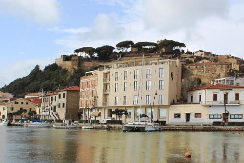 um grupo de edifícios e barcos em uma massa de água em Roma Hotel em Castiglione della Pescaia