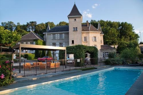 a house with a swimming pool in front of a house at Château & Spa De La Commanderie in Eybens