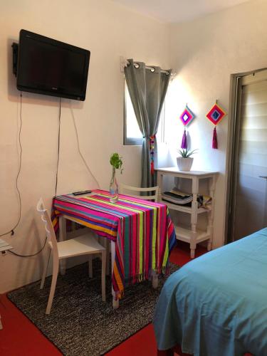 a room with a table and a tv on a wall at Cozy Little Apartment in Sayulita