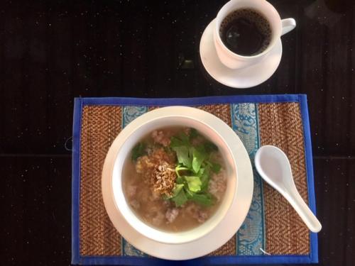 un tazón de sopa y una taza de café sobre una mesa en Harry's Beach Club, en Ban Phe