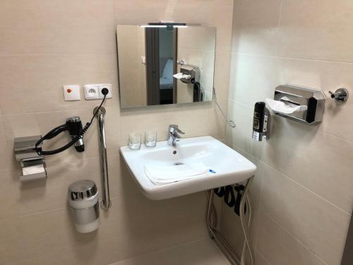 bagno con lavandino e specchio di Jukebox Hotel a Znojmo