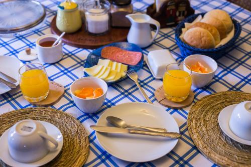 una mesa azul y blanca cubierta con platos y tazas de zumo de naranja en Hospedaje El Roble, Puerto Varas, en Puerto Varas