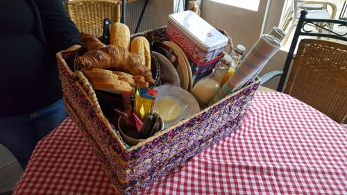 ein Korb mit Brot und Küchenutensilien auf dem Tisch in der Unterkunft De Turfstaeker in Ospel