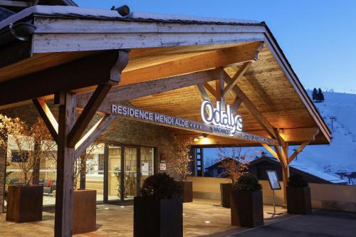 um edifício com uma placa na frente dele em Hôtel Prestige Odalys Le Chamois em La Clusaz