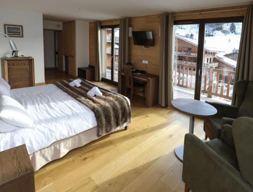 um quarto com uma cama grande e uma sala de estar em Hôtel Prestige Odalys Le Chamois em La Clusaz