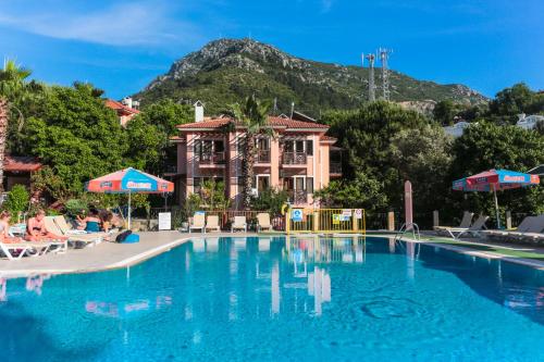 une grande piscine avec une montagne en arrière-plan dans l'établissement Club Pink Palace Hotel, à Ölüdeniz