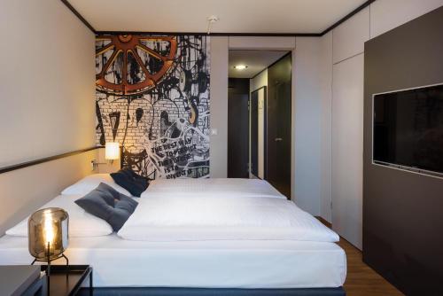 a bedroom with two beds and a wall with a clock at Seminaris Hotel Lüneburg in Lüneburg