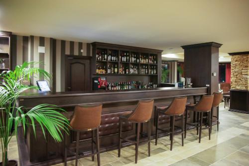 a bar with brown stools in a hotel room at Royal Park Hotel & Apartments in Bansko