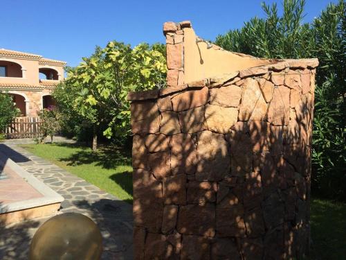 un mur en pierre devant une maison dans l'établissement Villa Oleandro - 2349447, à San Teodoro