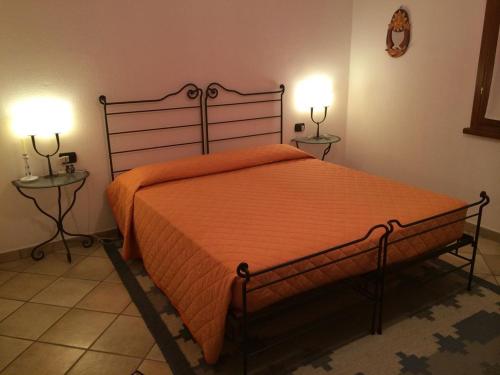 - une chambre avec un grand lit orange et 2 tables dans l'établissement Villa Oleandro - 2349447, à San Teodoro