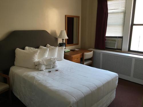 Habitación de hotel con cama blanca grande con almohadas blancas en Leo House, en Nueva York