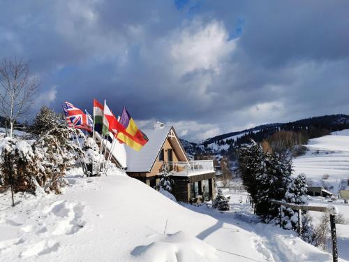 un rifugio con bandiere su una pista innevata di Jaworki Green Dream a Szczawnica