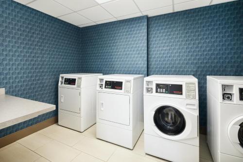 een wasruimte met 3 wasmachines en een wasmachine en droger bij Holiday Inn Express Richmond - Midtown, an IHG Hotel in Richmond