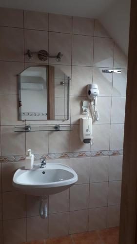 a bathroom with a sink and a mirror at The Corner House Panzió in Tata