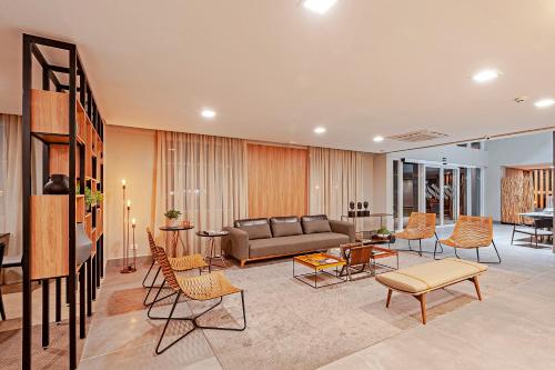 a living room with a couch and chairs at Slaviero Curitiba Aeroporto in São José dos Pinhais