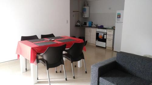 a dining room table with black chairs and a kitchen at Aloha III - El Palomar B&D in El Palomar