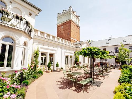 un patio avec des tables et des chaises et un bâtiment dans l'établissement Pokoje Gościnne WIDNOKRĄG, à Sandomierz