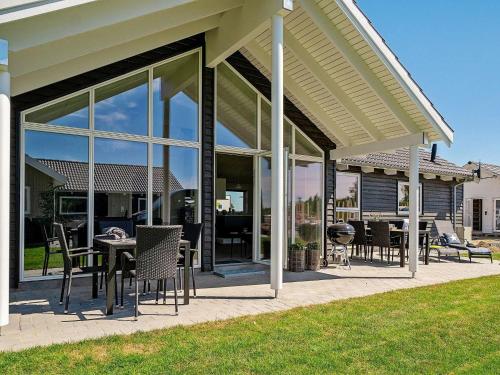 a patio with tables and chairs and glass doors at 12 person holiday home in Hasselberg in Kappeln