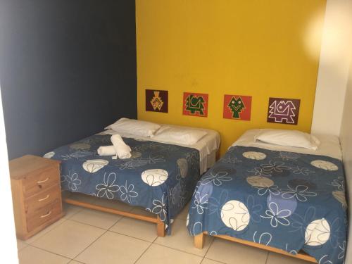 1 dormitorio con 2 camas individuales y vestidor en Paracas Backpackers House, en Paracas