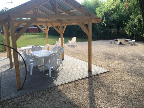 una mesa de picnic y sillas bajo un pabellón de madera en Fűzfa Vendégház, en Bogács