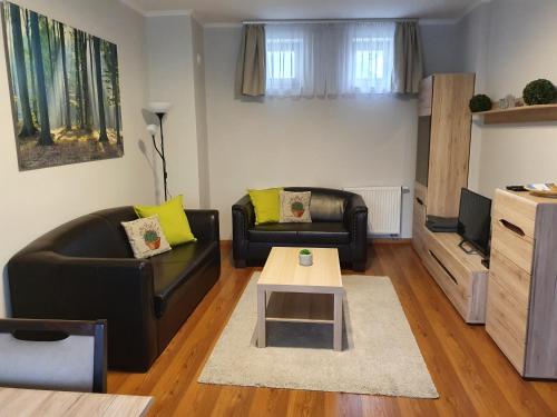 ein Wohnzimmer mit 2 Sofas und einem Couchtisch in der Unterkunft Gardenia Apartman in Esztergom