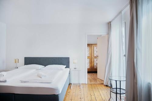 um quarto branco com uma cama grande e uma mesa em Gasthof Wastlwirt em Salzburgo