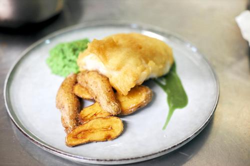 um prato branco com uma sanduíche e alguns anéis de cebola em Gasthof Wastlwirt em Salzburgo