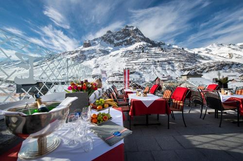 un restaurant avec vue sur une montagne enneigée dans l'établissement Hotel Enzian, à Zürs