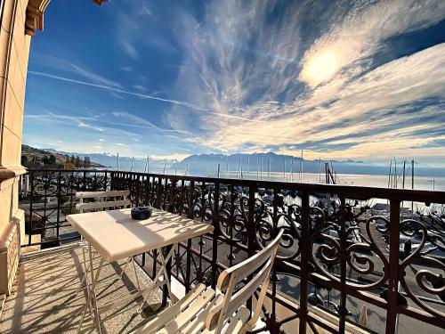 una mesa y sillas en un balcón con vistas al agua en Rivage Hotel Restaurant Lutry, en Lausana