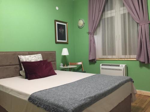 um quarto com uma cama e uma parede verde em Апартамент ELSOR em Burgas