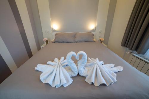 a bed with two swans made out of towels at Apartments Slana Oaza in Tuzla