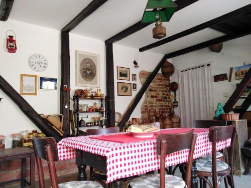 uma sala de jantar com uma mesa e cadeiras vermelhas e brancas em Sobe Gajić Sremski Karlovci em Sremski Karlovci